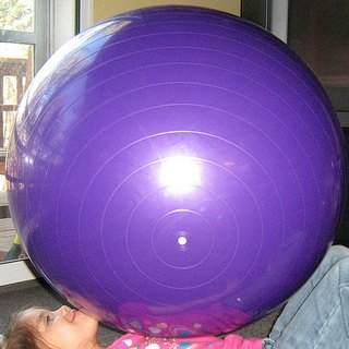 Child playing with large exercise ball