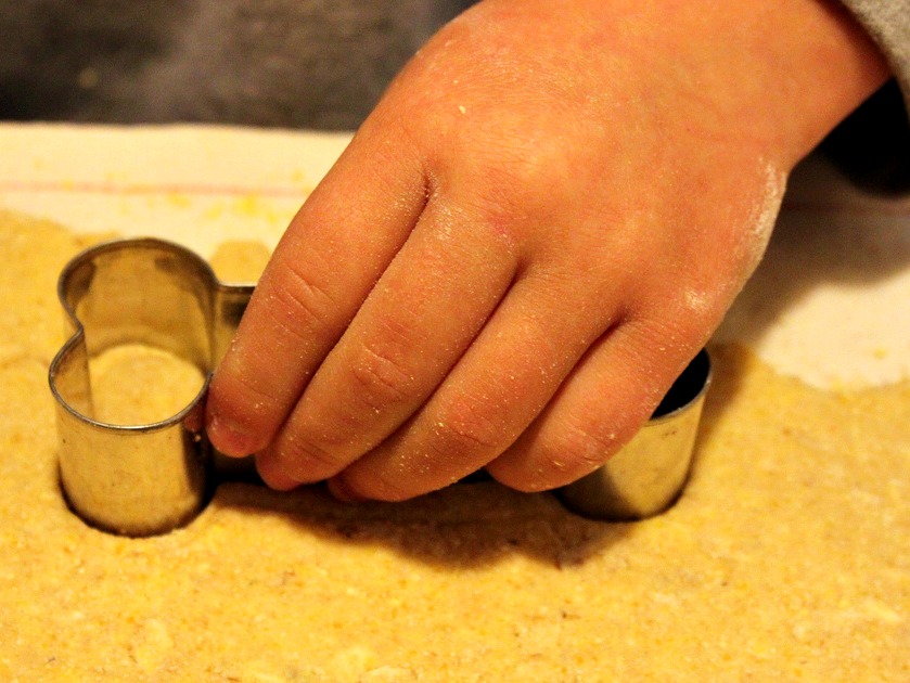 Cutting out bone-shaped dog treats from dough